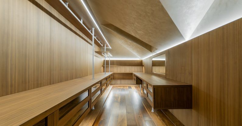 Timeless Wardrobe - A long wooden hallway with a lighted ceiling