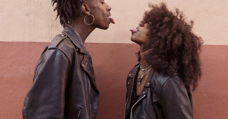 Leather Jackets - Young Couple Standing Face to Face and Sticking out Tongues